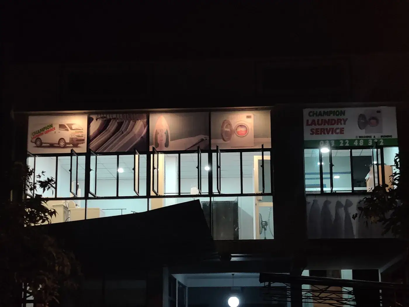 Champion Laundry Service shopfront lit up in the evening, Gampaha